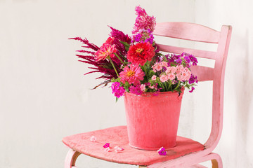 pink flowers in bucket on white background