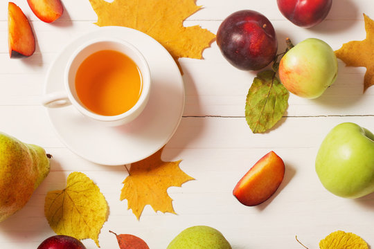 cup of tea with autumn leaves on wooden background