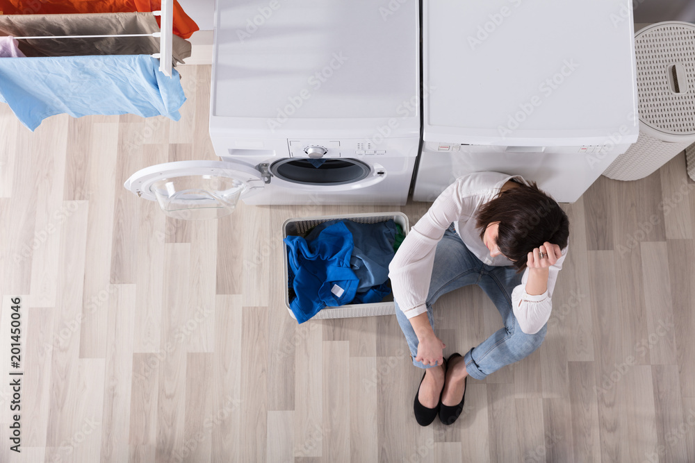 Wall mural Upset Woman Sitting At Laundry Room