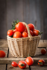 Small red cherry tomatoes  in a small wicker basket