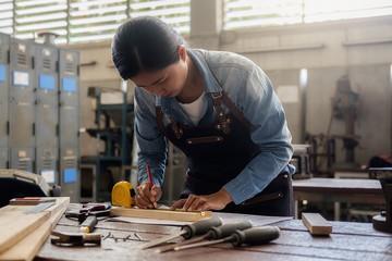Carpenter working on woodworking machines in carpentry shop. woman works in a carpentry shop.
