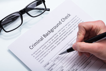 Person Filling Criminal Background Check Form