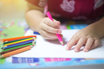 Children draw on white paper.