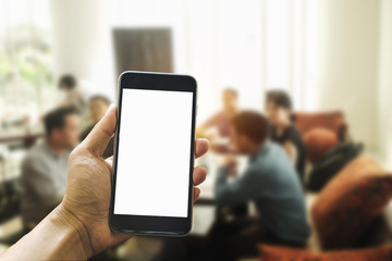 A man hand holding smart phone device in meeting room in morning light
