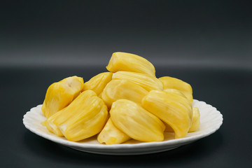 Fresh jackfruit slices on a white plate. sweet yellow jackfruit ripe. vegetarian, vegan, raw food. Exotic tropical fruit - isolated