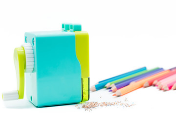 pastel blue yellow rotary pencil sharpener shavings with wooden colorful pencils isolated on white background, back to school education concept