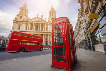 Londen, Engeland - Traditionele rode telefooncel met iconische rode vintage dubbeldekkerbus in beweging in St.Paul& 39 s Cathedral op een zonnige dag