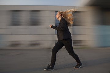 Mujer de negocios corriendo estresada a toda velocidad por la calle. 