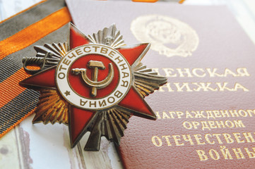 Close up of an award Patriotic war, the medal book and the St.George's Ribbon on a table.