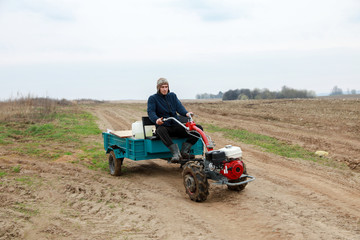 farmer on a small tractor with a trailer