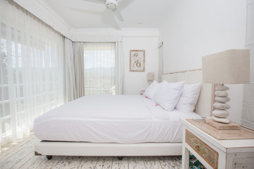 Bright light white clean stylish interior bedroom with a large panoramic window beautiful view