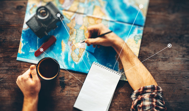 Unrecognizable Traveler Hands Planning Vacation Travel With Map, Top View. He Drinks Coffee And Marks