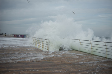 huge waves cover the pier during a storm