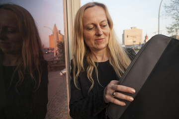 mujer de negocios mirando dentro de una funda para documentos o laptop.