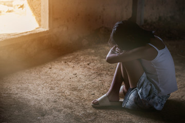 Sad little girl sitting on the floor in old home, sad depression,violence concept,hard contrast
