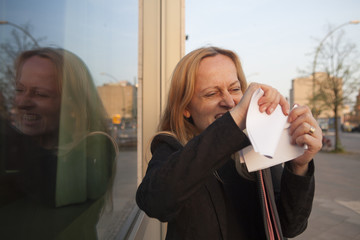 Mujer de negocios frustrada y en desacuerdo rompiendo un documento de papel en trocitos
