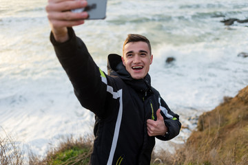 Fototapeta premium the guy makes a happy selfie on the precipice