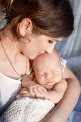 Pretty woman holding a newborn baby in her arms