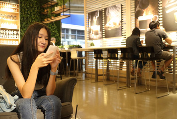 young Asian woman using smartphone, closeup portrait.
