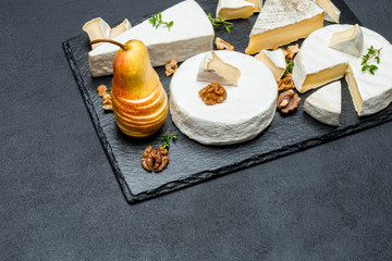 Camembert cheese and pear on stone board