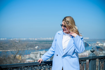 A woman of plus size, American or European appearance walks at city streets enjoying life. A young lady with excess weight, have a stylish dress. Natural beauty 