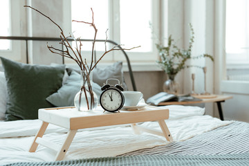 Time to Wake up! Vintage alarm clock on the shelf in the bedroom on home flowers background