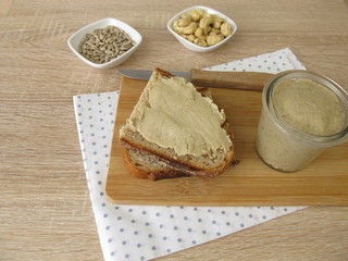 Selbst gemachtes veganes Nussmus aus Cashewkernen und Sonnenblumenkernen auf einer Brotscheibe