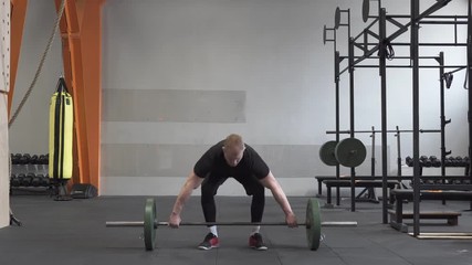 Fitness man doing barbell snatch exercise in gym
