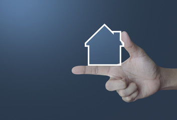 Fototapeta na wymiar House icon with copy space on finger over light gradient blue background, Real estate concept