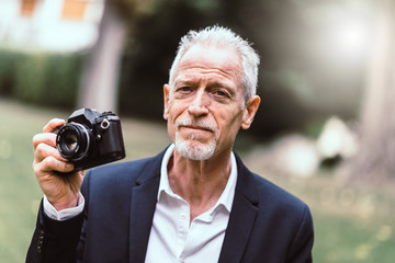 Mature man taking pictures, light effect