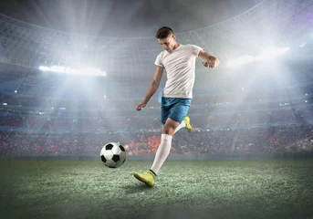 Fotobehang Soccer player on a football field in dynamic action at summer da © Andrii IURLOV