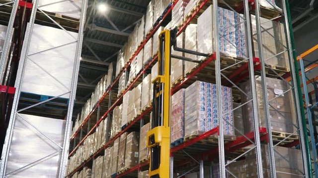 Lift truck in factory. Clip. Wholesale logistic, loading, shipment and people concept - man with loader carrying cargo at warehouse