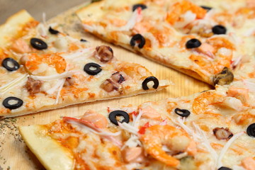 pizza thin olive shrimp crabs on a wooden stand macro photography