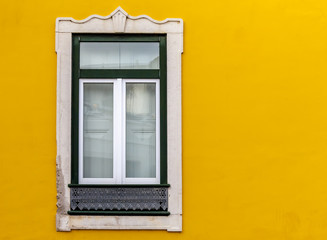 Fototapeta na wymiar Window on yellow facade building during afternoon journey
