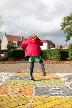 Little girl playing hopscotch