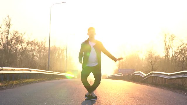 A ballet dancer performs an anthrax jump in the middle of the road at dawn, leaks. Slow motion