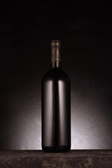 Fototapeta na wymiar single bottle of luxury red wine on black