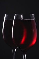 close-up shot of glasses full of luxury red wine on black