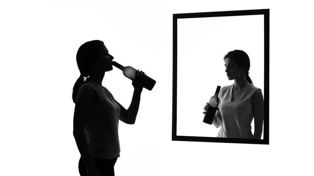 Drunk woman with alcohol bottle looking in mirror, conscience asking to stop