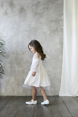 Children's fashion. Little stylish girl in white dress.