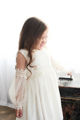 Children's fashion. Little stylish girl in white dress.