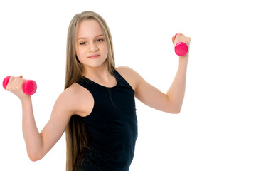 Little girl doing exercises with dumbbells.
