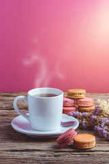 Different types color of macaroons with Cup of hot tea on Old grunge wooden background