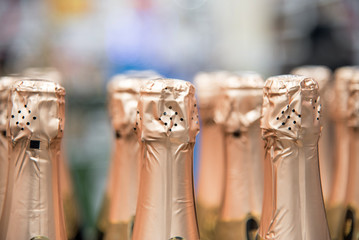 Naklejka na ściany i meble Bottles of celebratory champagne in the store. Many bottles in the wine store.