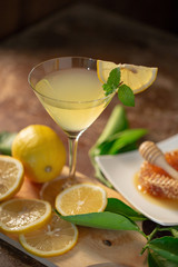 Lemon juice with honey on wooden table,  lemons and sage leaves