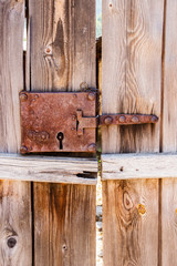 Close-up of a plank door with old rusted lock