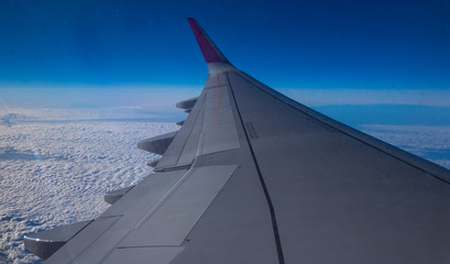 Fototapeta na wymiar Airplane wing above the clouds