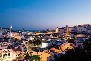 Fototapeta na wymiar Panoramic, night view of the Old Town of Albufeira City in Algarve, Portugal. Albufeira is a coastal city in the southern Algarve region of Portugal. 