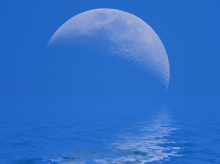 View of the Moon on the blue sky reflecting in water.