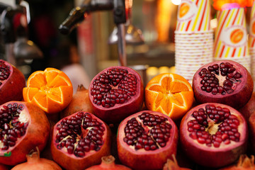 Pomegranate and orange with disposable paper cup are ready for juice extractor on the street in...